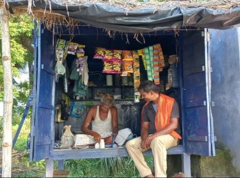 Ram Bihari in his wooden stall where he mends shoes and sells grocery as well.