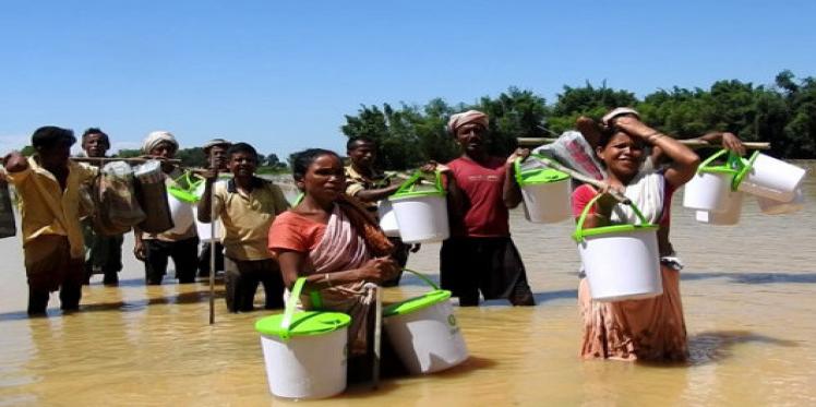 Affected people holding Oxfam buckets