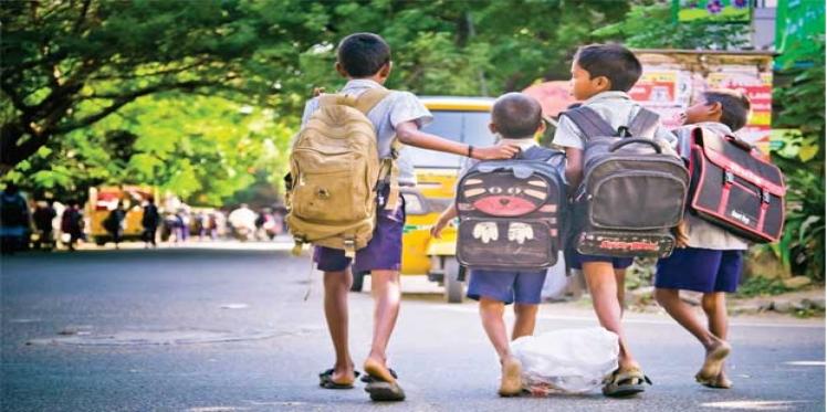A group of school children walking on the road