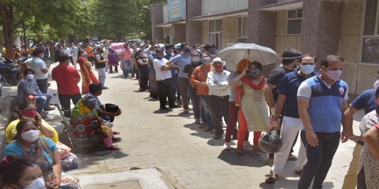 People wait for their turn to get a dose of COVID-19 vaccine