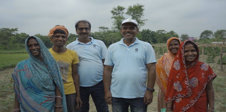 Oxfam India team with the women farmers. Shripati in Orange saree. 