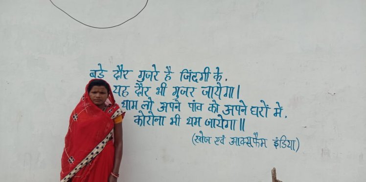 A woman stands next to a slogan on Coronavirus (Korba)